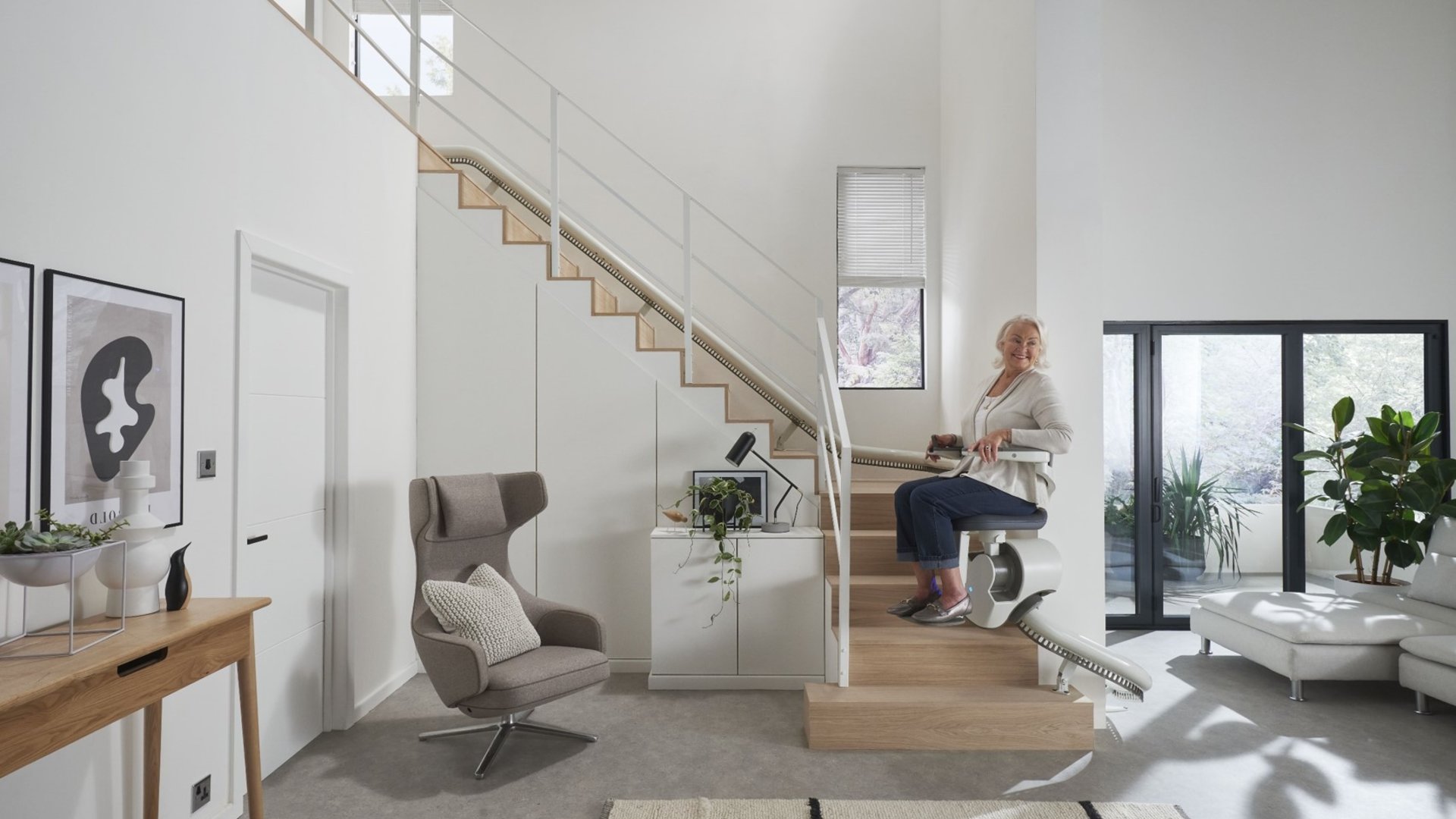 Woman travelling up the stairs of her house in an Orona stairlift