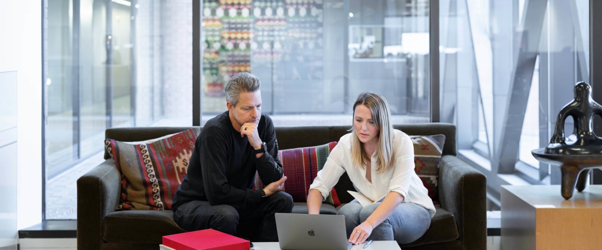 man and woman at the computer in a spacious office