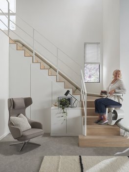 Señora subiendo las escaleras de su casa en una silla salvaescaleras de Orona