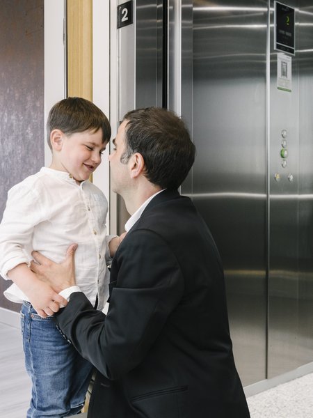 Vader en zoon op de overloop bij de Orona lift