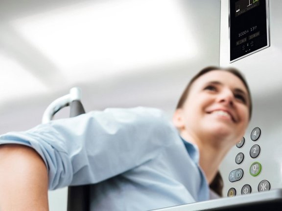 een vrouw in een rolstoel op een cabineplatformlift