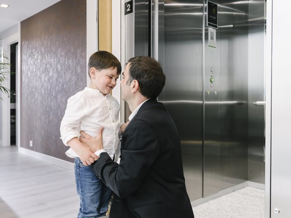 Pai e filho no patamar junto ao elevador Orona