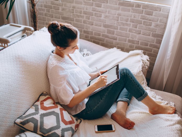 mulher no sofá a navegar na Internet com o iPad