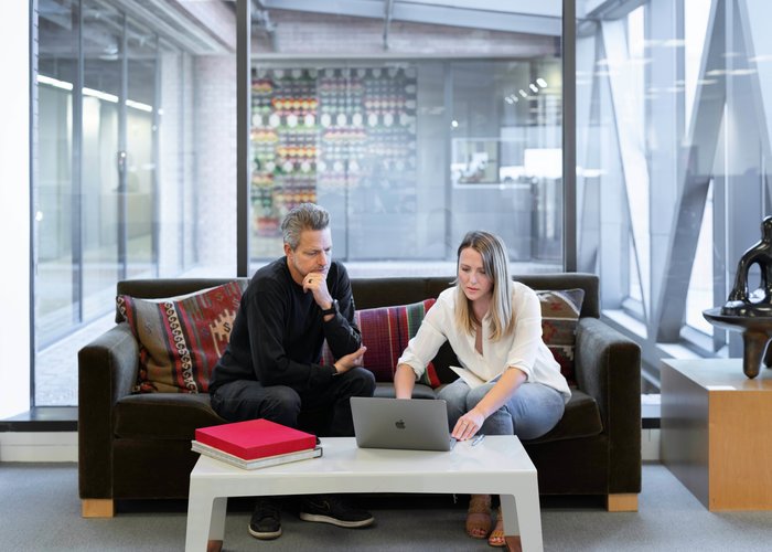 homme et femme avec un ordinateur dans un grand bureau